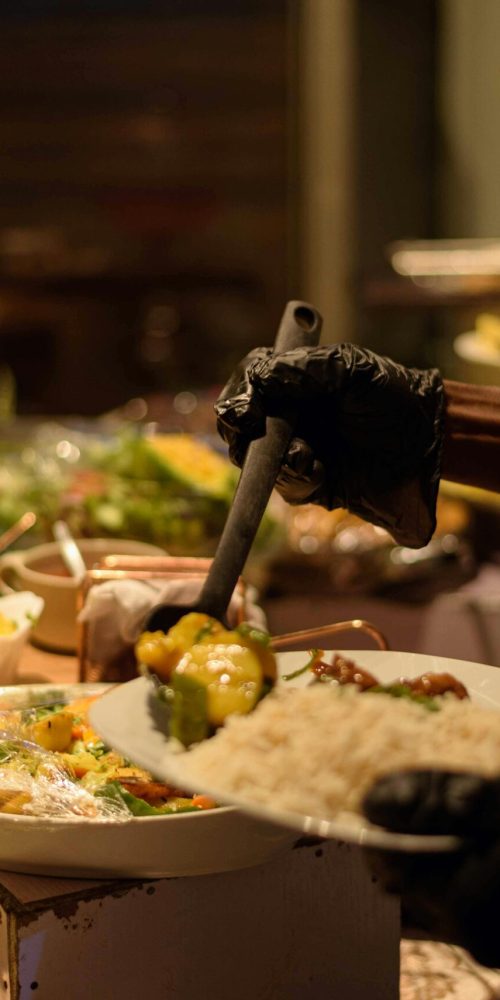 A chef serving traditional Nigerian dishes at an elegant buffet in Enugu, Nigeria.